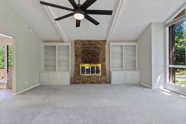 unfurnished living room featuring a wealth of natural light, light carpet, a fireplace, and lofted ceiling with beams