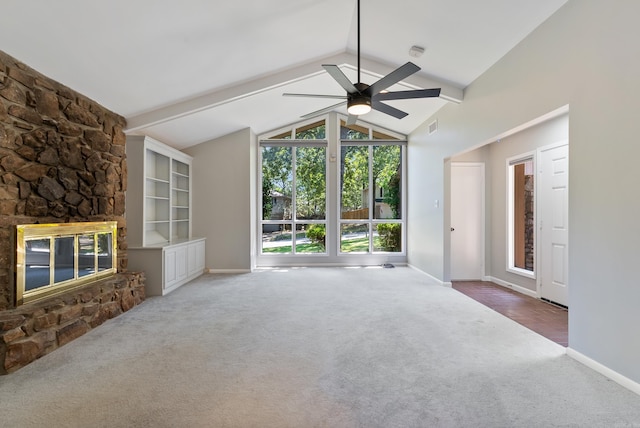 unfurnished living room featuring a fireplace, carpet floors, ceiling fan, and lofted ceiling with beams