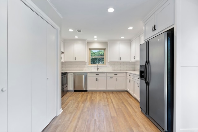 kitchen featuring white cabinetry, sink, stainless steel appliances, and light hardwood / wood-style flooring