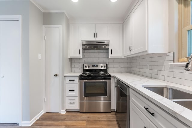 kitchen with sink, appliances with stainless steel finishes, light hardwood / wood-style flooring, light stone countertops, and white cabinets