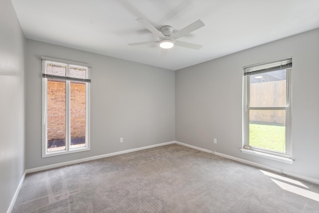 carpeted spare room with ceiling fan and a wealth of natural light