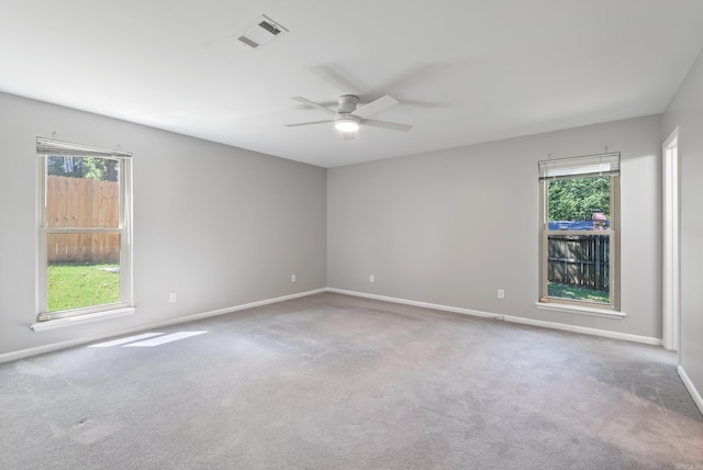 carpeted empty room featuring plenty of natural light and ceiling fan