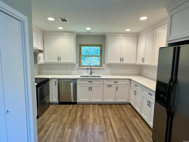 kitchen featuring sink, white cabinets, appliances with stainless steel finishes, and wood-type flooring