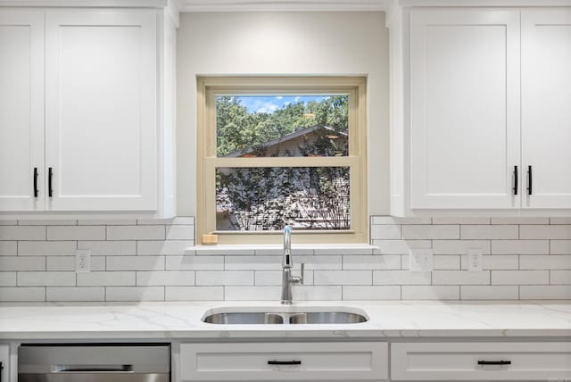 kitchen with sink, light stone countertops, tasteful backsplash, dishwasher, and white cabinetry