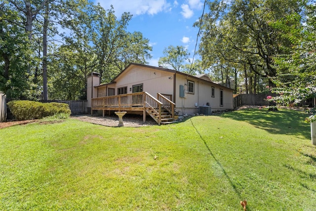 rear view of property featuring a wooden deck, central air condition unit, and a yard