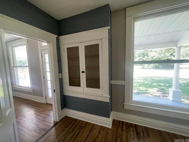 foyer entrance featuring dark wood finished floors and baseboards