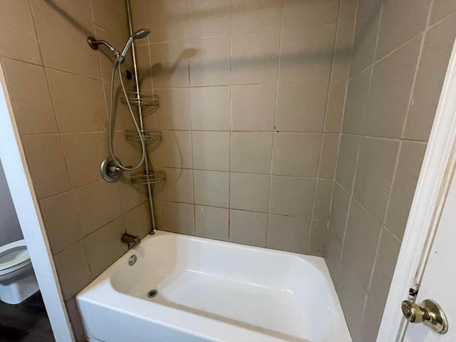 bathroom featuring shower / tub combination and toilet