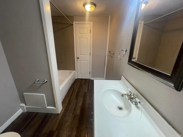 full bathroom with shower / bath combination, wood finished floors, vanity, and baseboards