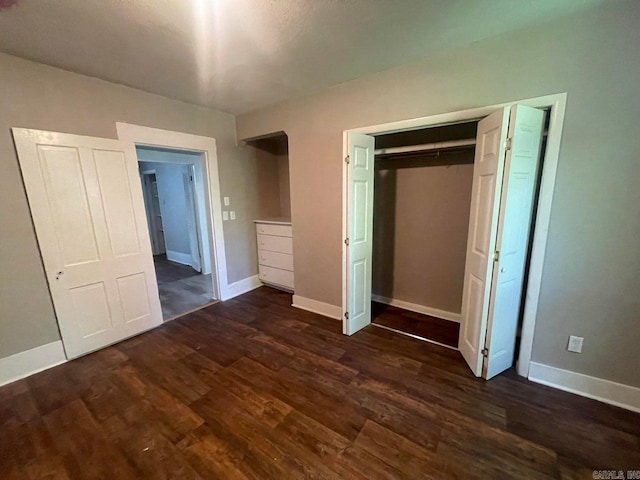 unfurnished bedroom featuring dark wood-type flooring and a closet