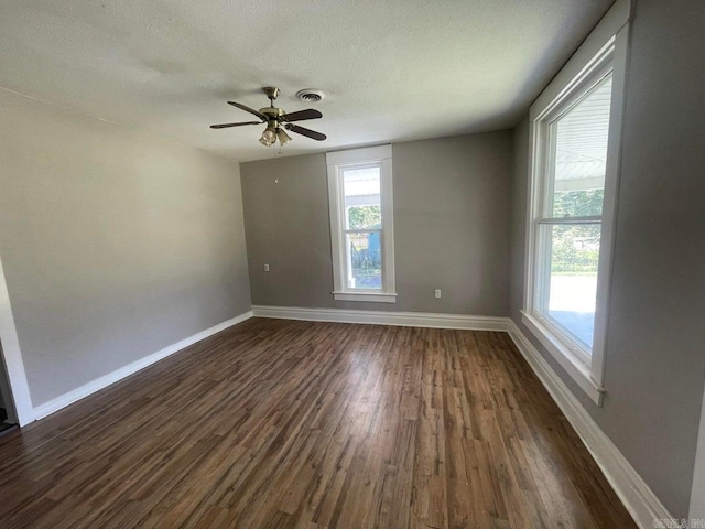 empty room featuring dark hardwood / wood-style flooring, a textured ceiling, and ceiling fan