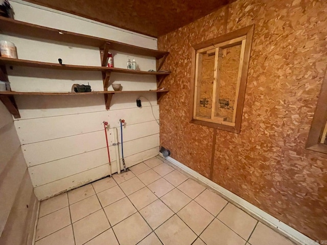 laundry area featuring light tile patterned floors, laundry area, hookup for a washing machine, and baseboards