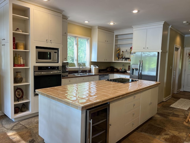 kitchen with beverage cooler, tile countertops, stainless steel appliances, open shelves, and a sink