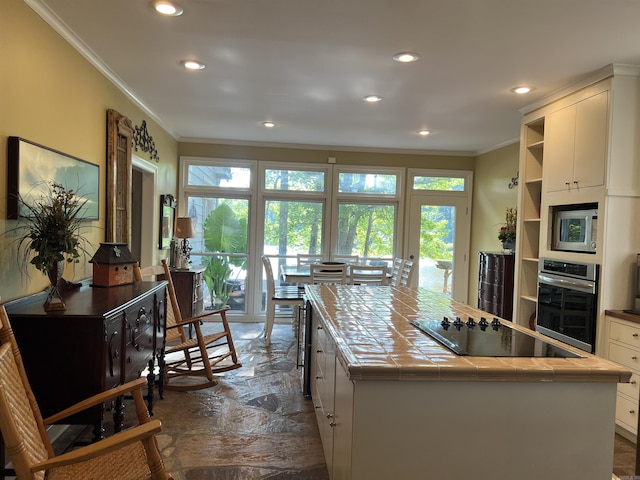 kitchen featuring ornamental molding, open shelves, appliances with stainless steel finishes, and tile counters