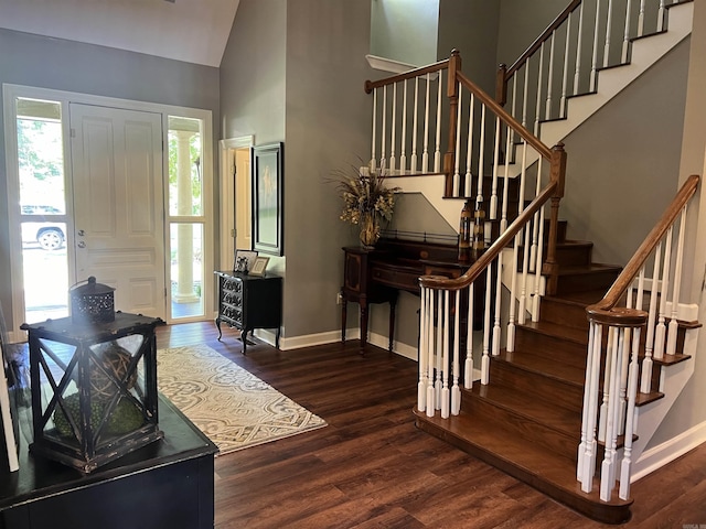 entrance foyer with stairs, a high ceiling, baseboards, and wood finished floors