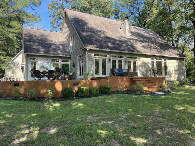 exterior space featuring french doors, roof with shingles, a chimney, a deck, and a front lawn