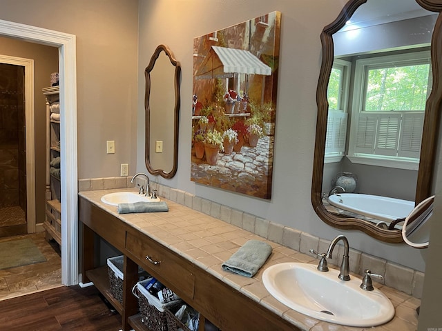 bathroom featuring double vanity, wood finished floors, and a sink