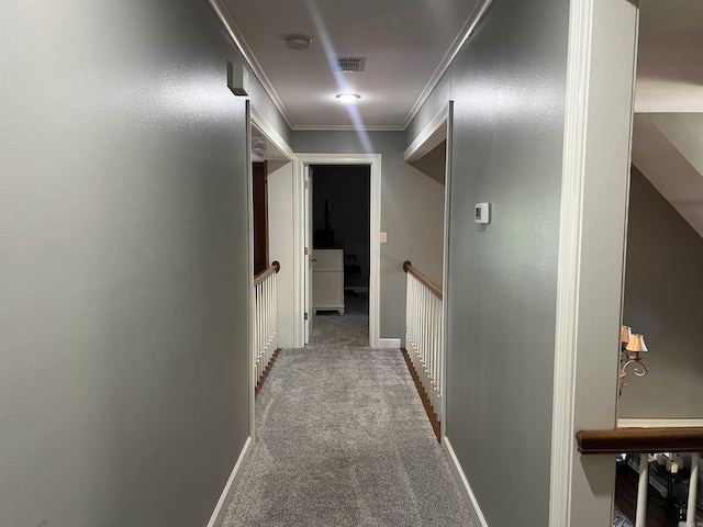 hall featuring carpet, visible vents, ornamental molding, and baseboards