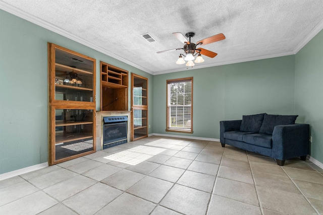 unfurnished living room with light tile patterned floors, ornamental molding, ceiling fan, and a textured ceiling