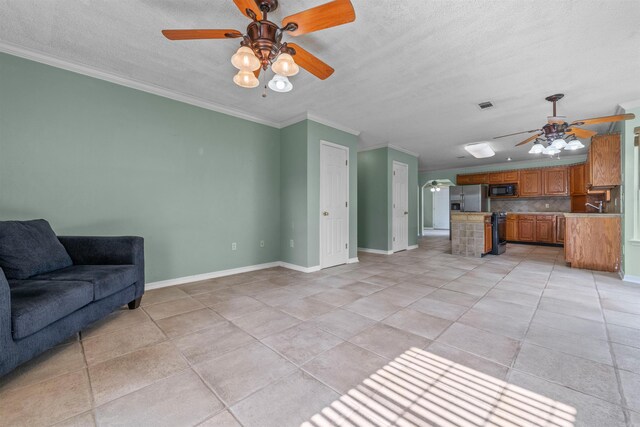 living room featuring ceiling fan, light tile patterned flooring, a textured ceiling, and ornamental molding