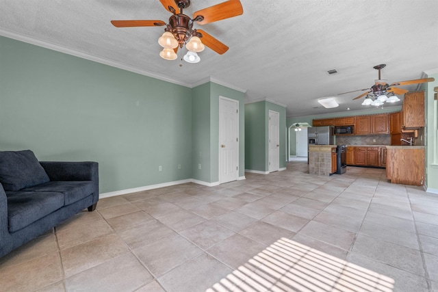 living room featuring visible vents, ornamental molding, a ceiling fan, and baseboards