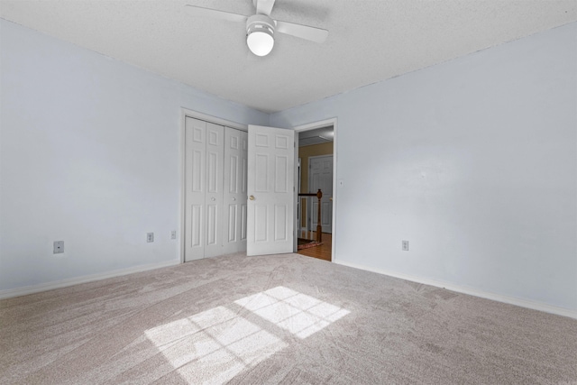 unfurnished bedroom featuring a textured ceiling, carpet floors, a closet, and baseboards