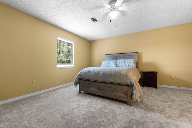 bedroom featuring a textured ceiling, ceiling fan, and light carpet