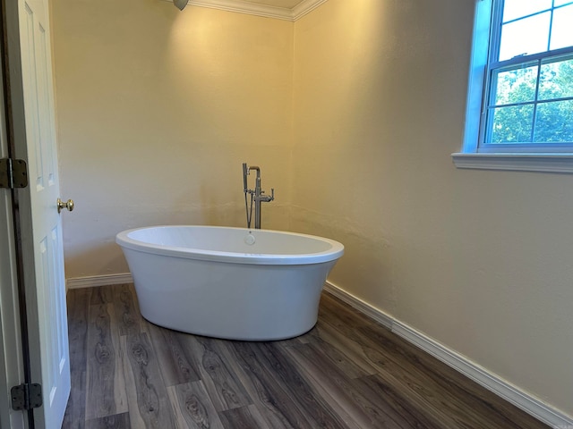 bathroom with crown molding, a bathtub, and wood-type flooring