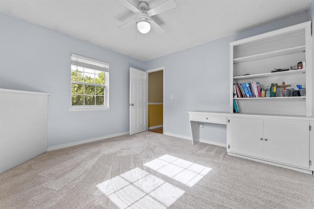 interior space featuring ceiling fan, light colored carpet, a closet, and a textured ceiling