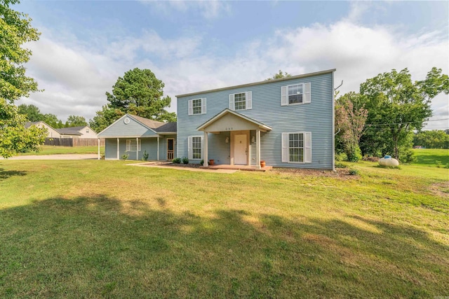 view of front of home with fence and a front lawn