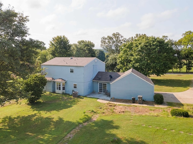 rear view of house with a patio area, a lawn, and central air condition unit