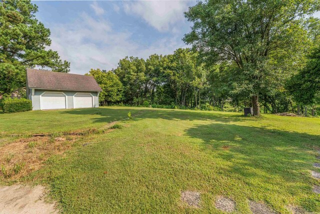 view of yard featuring a garage and an outbuilding