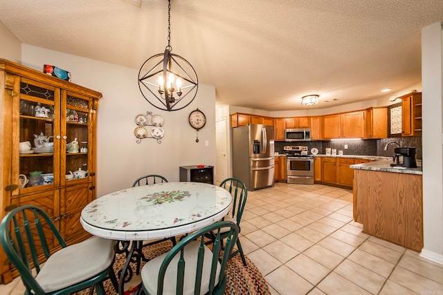 tiled dining area with sink, a textured ceiling, and a chandelier