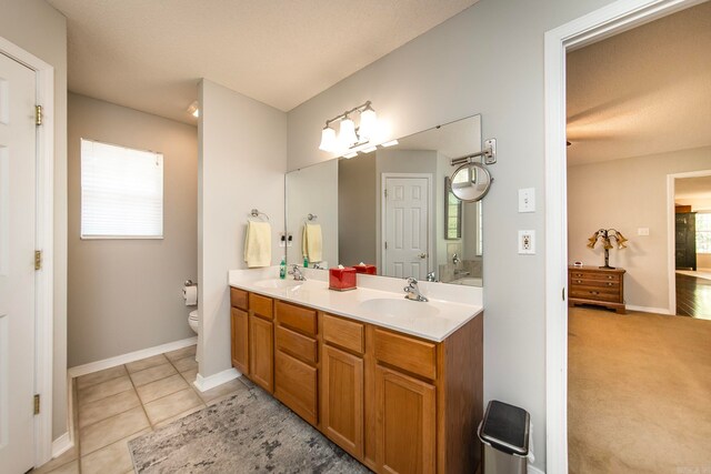 bathroom featuring a wealth of natural light, toilet, tile patterned flooring, and vanity