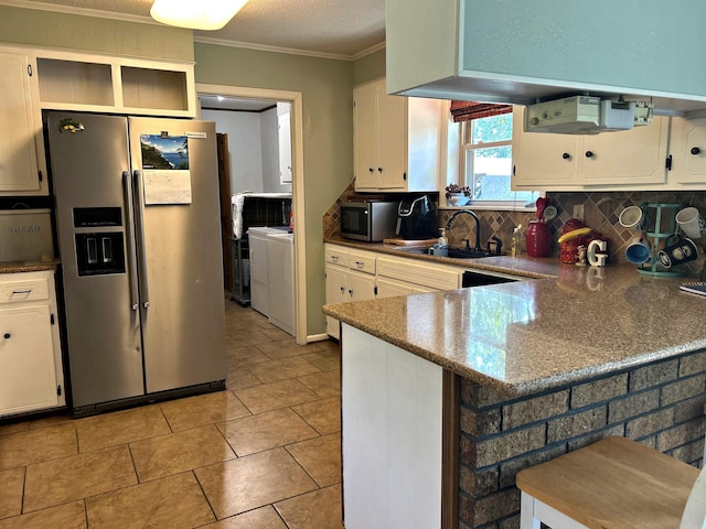 kitchen featuring separate washer and dryer, tasteful backsplash, white cabinets, sink, and stainless steel appliances