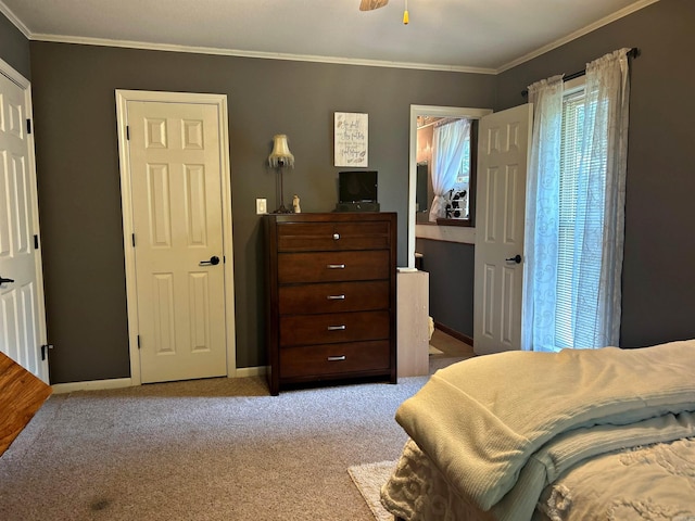 carpeted bedroom with ceiling fan and ornamental molding