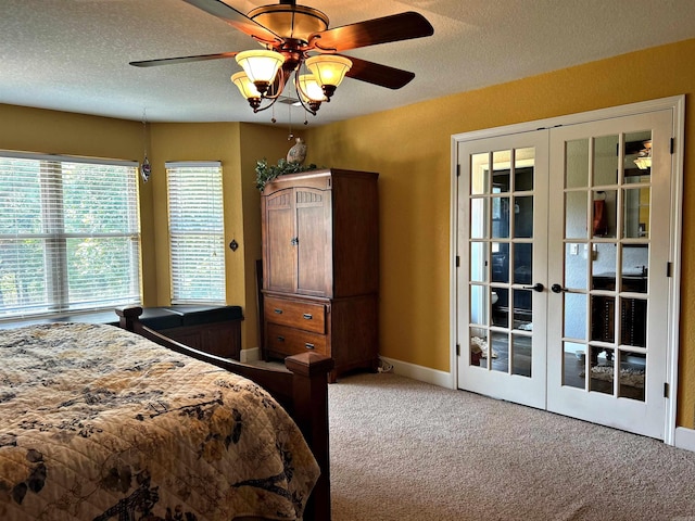 carpeted bedroom featuring a textured ceiling, ceiling fan, and french doors