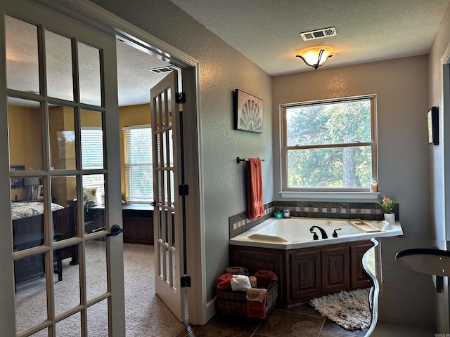 bathroom featuring a textured ceiling and a bath