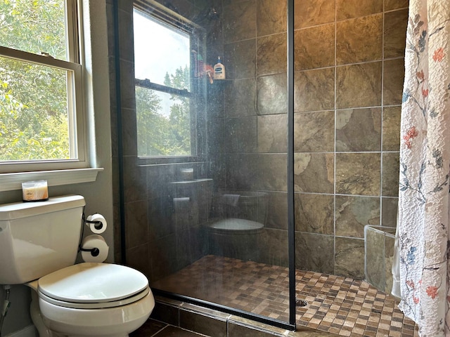 bathroom featuring toilet and a tile shower