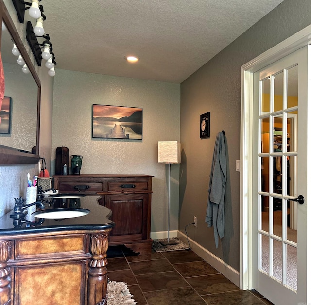 bathroom with a textured ceiling, vanity, and tile patterned floors