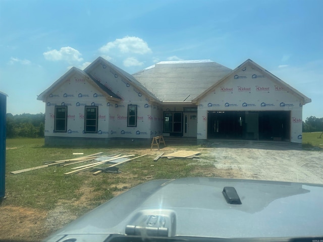 property in mid-construction featuring a front yard and a garage