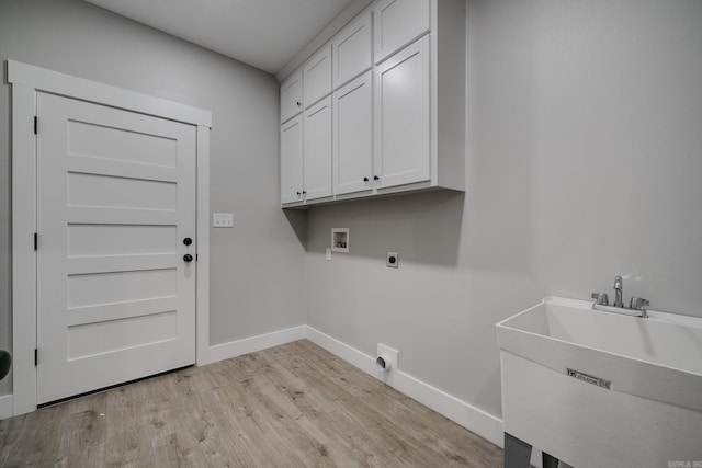 laundry room featuring electric dryer hookup, cabinets, sink, hookup for a washing machine, and light hardwood / wood-style floors