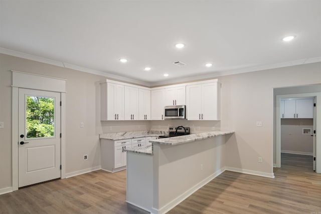 kitchen with light hardwood / wood-style flooring, stainless steel appliances, and white cabinets