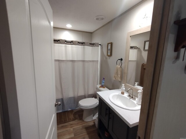 full bathroom with hardwood / wood-style floors, shower / bath combo, toilet, and vanity