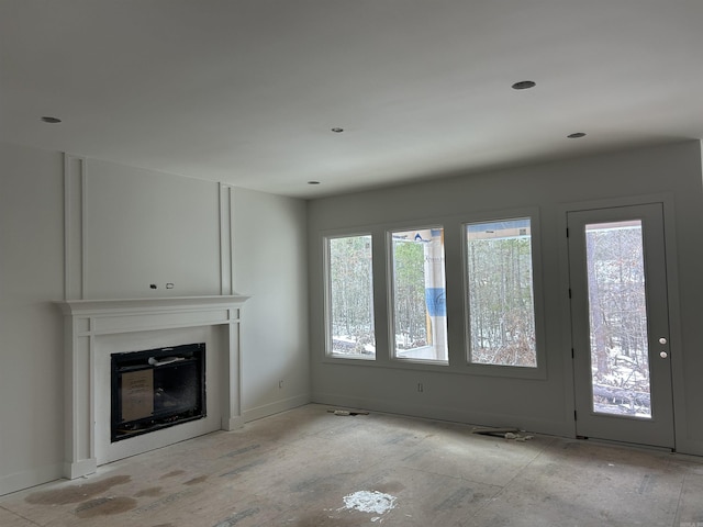 unfurnished living room featuring a glass covered fireplace