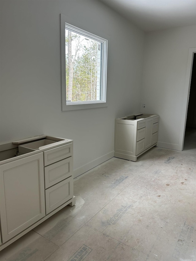 laundry area with baseboards