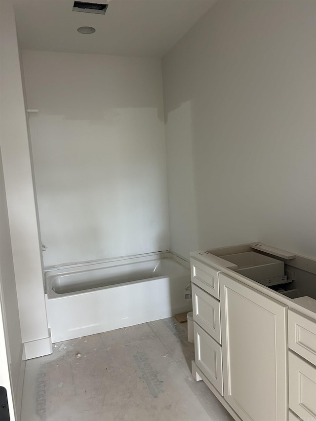 bathroom featuring a washtub, unfinished concrete flooring, and vanity