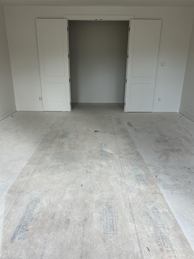 unfurnished room with baseboards