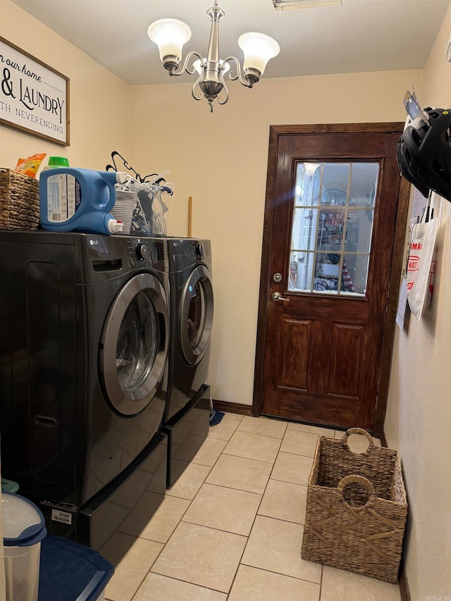 clothes washing area featuring separate washer and dryer, light tile patterned floors, and an inviting chandelier