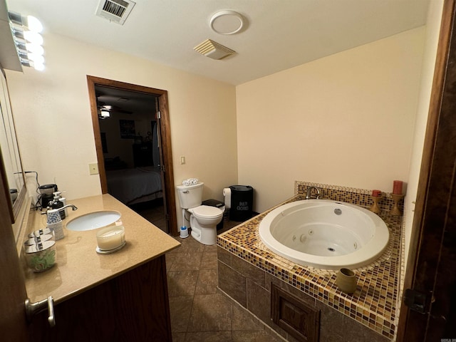 bathroom with toilet, vanity, tile patterned floors, a bathing tub, and ceiling fan