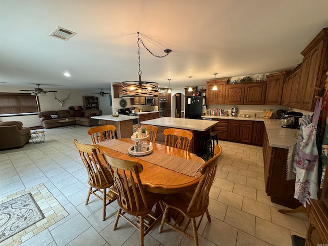 dining area featuring ceiling fan with notable chandelier and light tile patterned floors